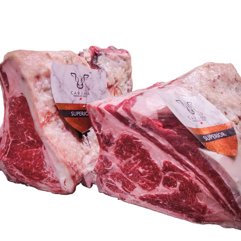 Μπριζόλα ράχης με κόκαλο Carima Superior Ιταλίας με ενισχυμένο μαρμάρωμα, ψημένη στη σχάρα και κομμένη σε ζουμερές φέτες πάνω σε ξύλο κοπής.