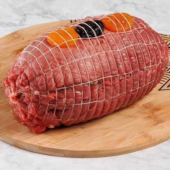 Ρολό μαύρου χοίρου γεμιστό με αποξηραμένα φρούτα και ξηρούς καρπούς έτοιμο για ψήσιμο.